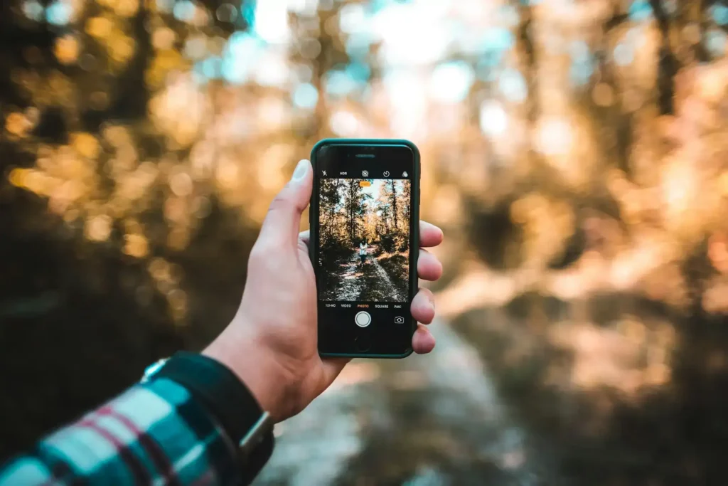 Smartphone mostrando una publicación llamativa de Instagram con el texto “¿Quieres crecer en Instagram sin pagar?”, acompañada de emojis, corazones y elementos visuales de engagement. Ideal para emprendedores que quieren aprender cómo crecer en Instagram sin publicidad y captar clientes con contenido visual.